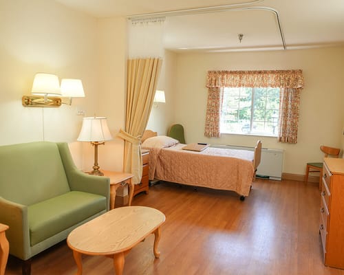 Private room in a senior living facility with furniture