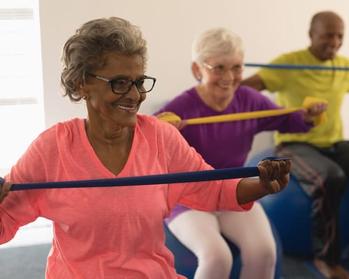 Residents participating in a fitness class with resistance bands