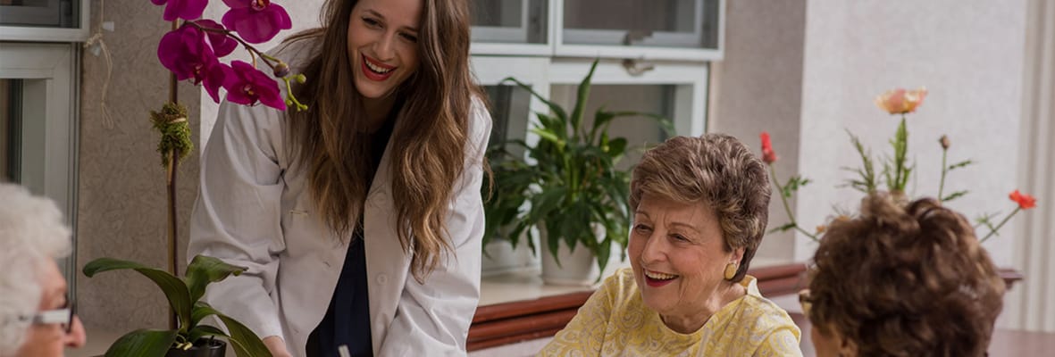 Staff interacting with residents in a sunny common area