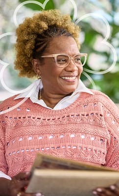 Smiling resident enjoying a book in a cozy setting