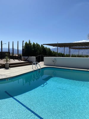 Outdoor pool area with clear blue water and seating