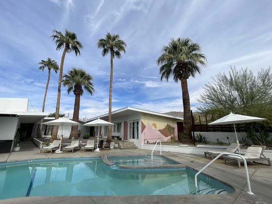 Outdoor pool area with palm trees and lounge chairs