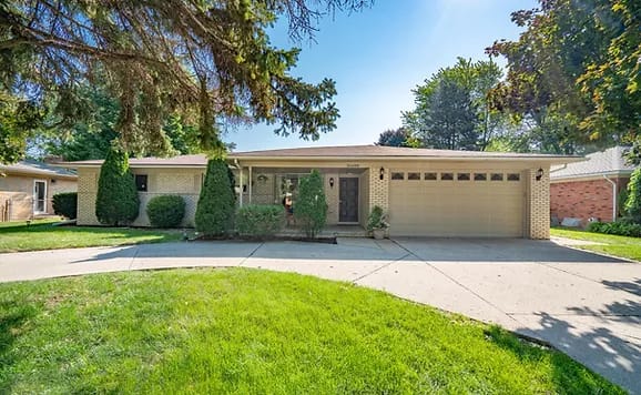 Exterior view of a residential building with a landscaped yard
