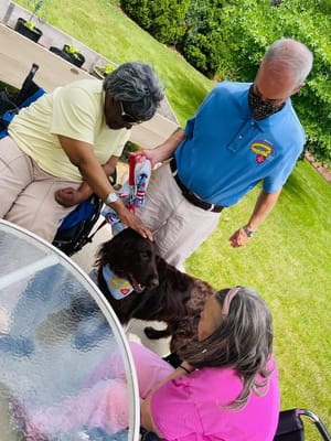 Residents interacting with a therapy dog outdoors