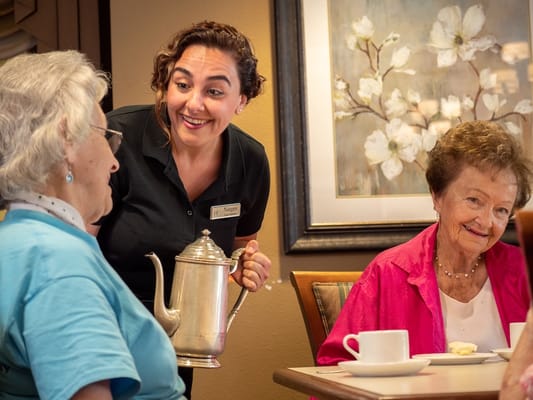 Staff interacting with two residents in a social setting