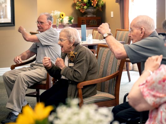 Residents participating in a seated exercise class