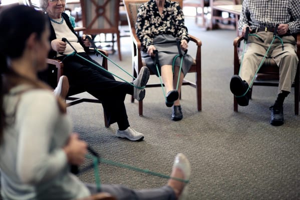 Residents participating in a seated exercise class