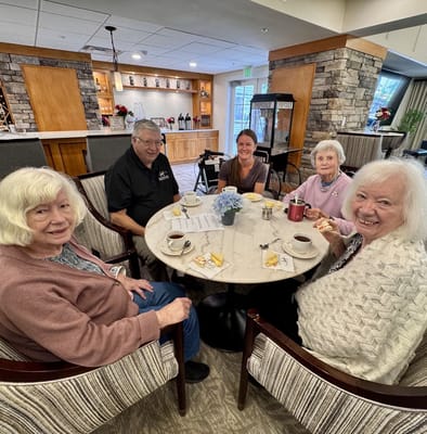 Residents enjoying coffee and snacks at a dining room table