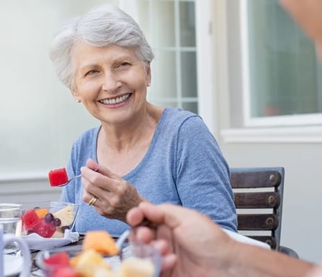 Senior resident enjoying a meal with fruit