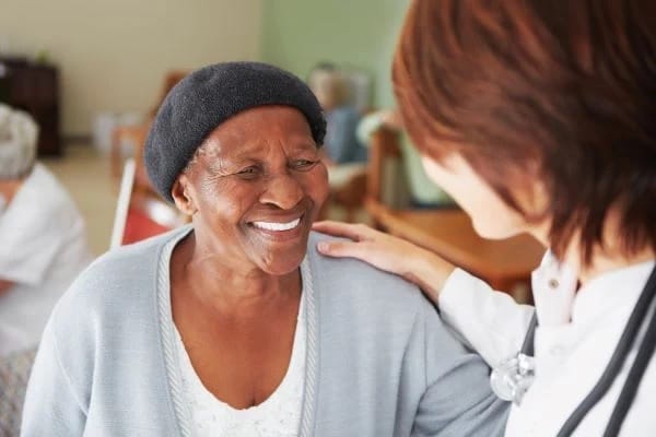 A caregiver interacting with a smiling resident