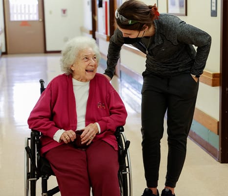 Staff member interacting with a resident in a hallway