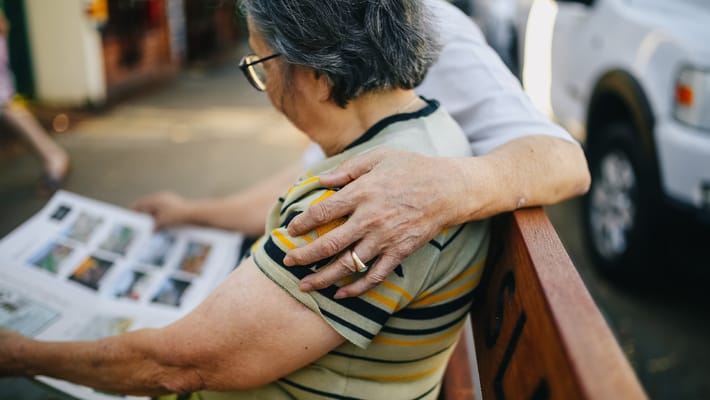 Two residents sharing a moment while looking at a photo book