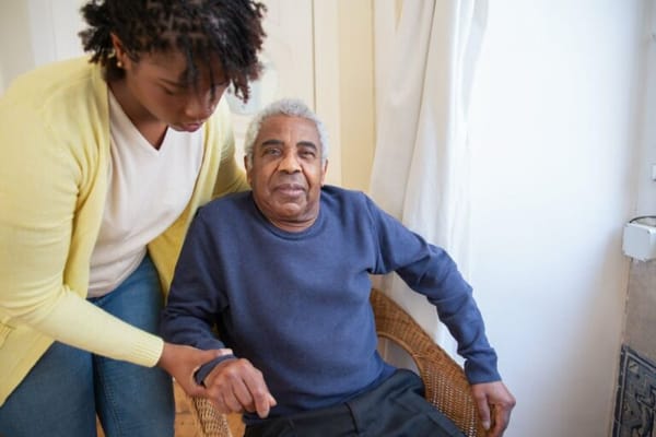 Caregiver assisting a senior resident in a cozy room