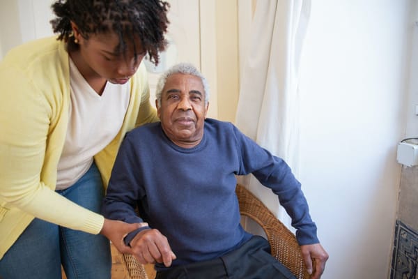 Caregiver assisting a senior resident in a cozy room
