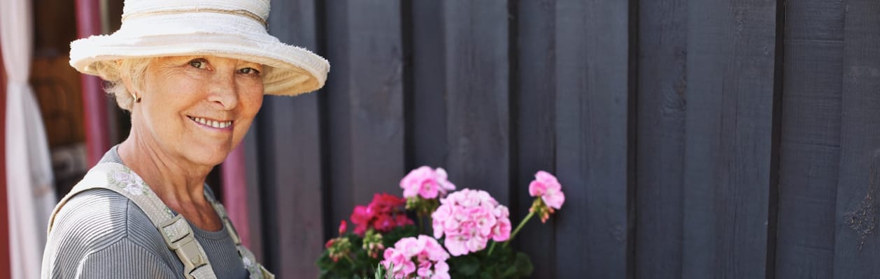 Senior woman tending to flowers in a garden