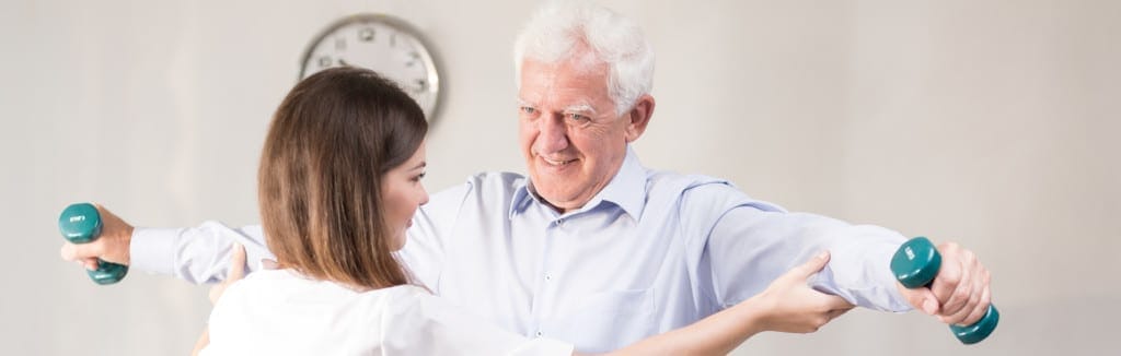 A senior man engaging in exercise with a caregiver