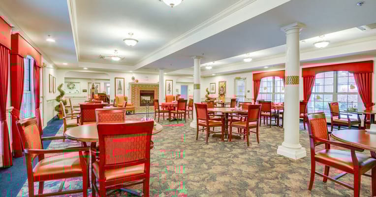 Interior view of a bright common area with dining tables