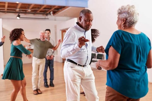 Residents dancing joyfully in a spacious activity room