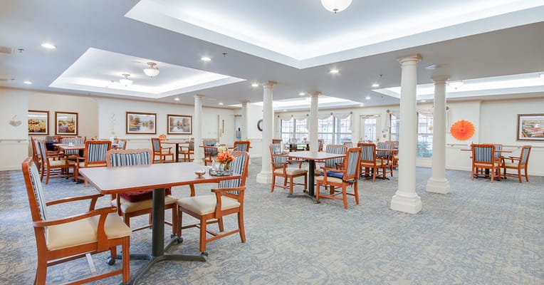 Bright dining room with tables and chairs for residents