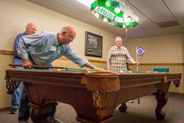 Seniors playing billiards in an activity room