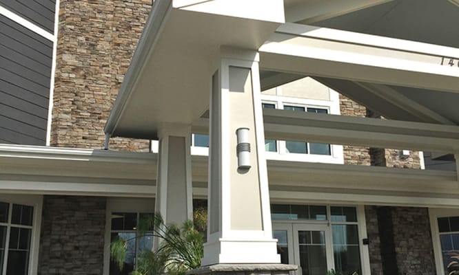 Entrance view of a senior living facility with stone facade