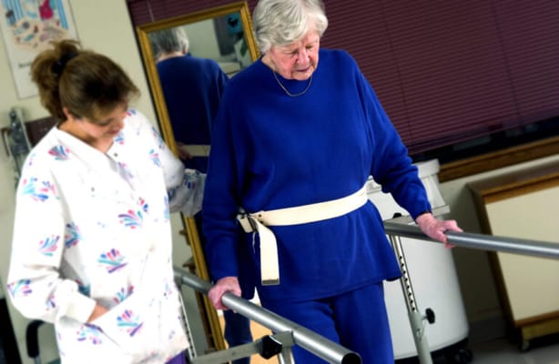 A caregiver assisting a resident at a therapy session