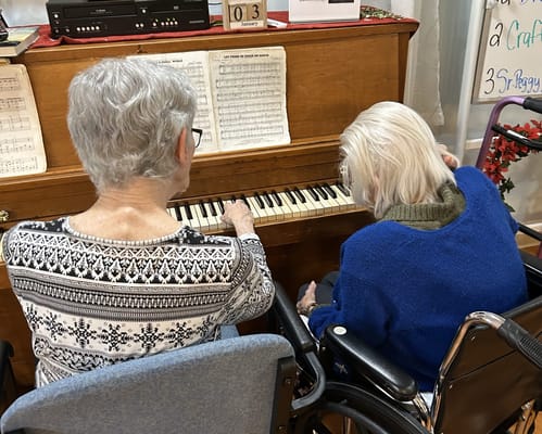 Residents playing piano in a common area