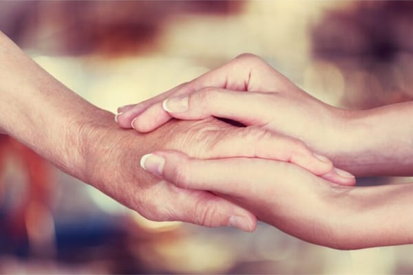 Two hands holding each other gently