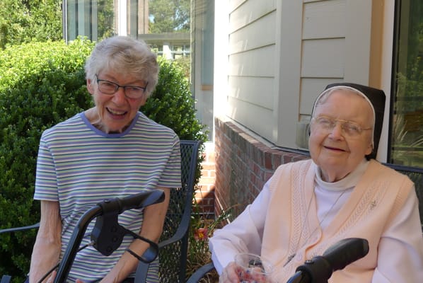 Two smiling residents enjoying time outdoors