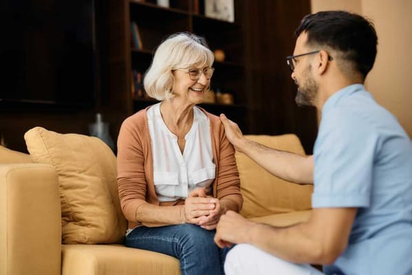 Caregiver talking with a smiling resident in a cozy setting