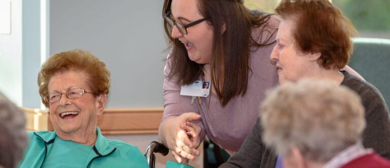Residents engaging with staff in a social activity