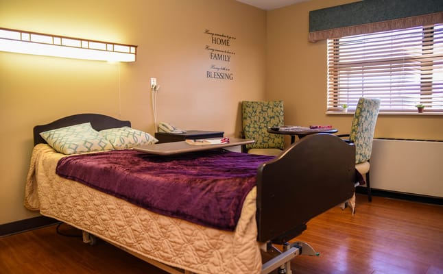 A cozy resident room with a bed and window seating