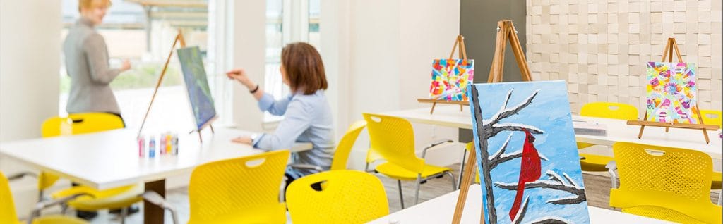 Residents participating in an art class in a bright activity room