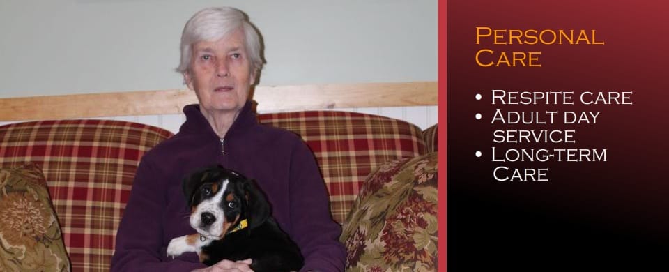 Resident sitting with a dog in a cozy lounge area