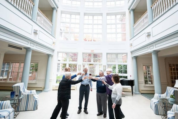 Residents toasting with drinks in a sunny lounge