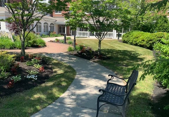 Garden pathway with bench and flowering plants