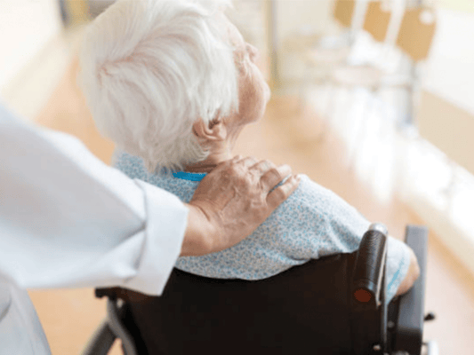 Healthcare professional comforting an elderly patient