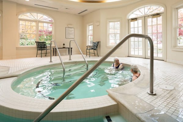 Two residents enjoying the spa in a warm indoor setting