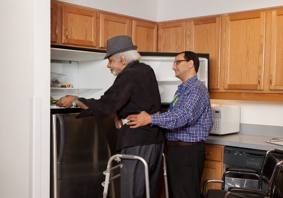 Staff assisting a resident in a kitchen