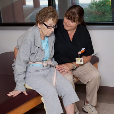 Staff assisting a resident in a cozy indoor space