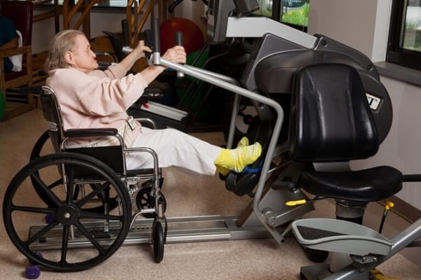 Resident exercising in a wheelchair in a gym