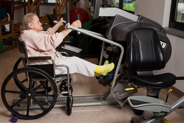 Resident exercising in a wheelchair in a gym