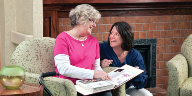Two residents engaging with a photo album in a cozy setting