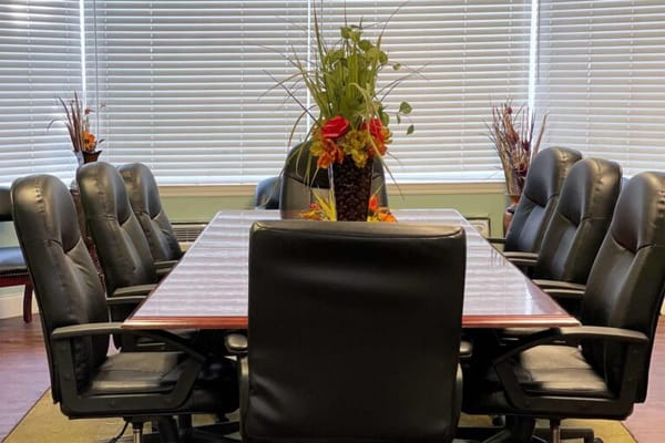 Meeting room with a large table and black chairs