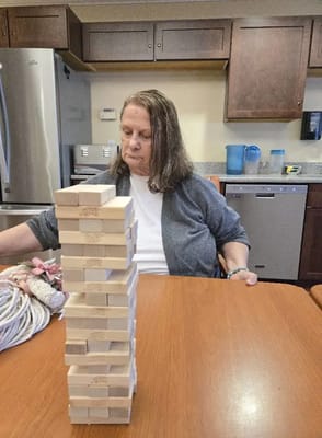 Resident playing Jenga in an activity room