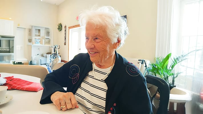 A senior woman smiling in a bright common area