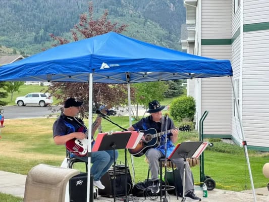 Musicians performing under a tent outside the facility