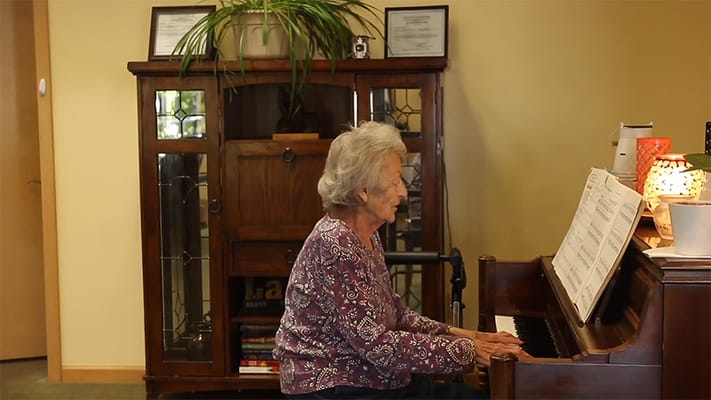 A resident playing piano in a common space