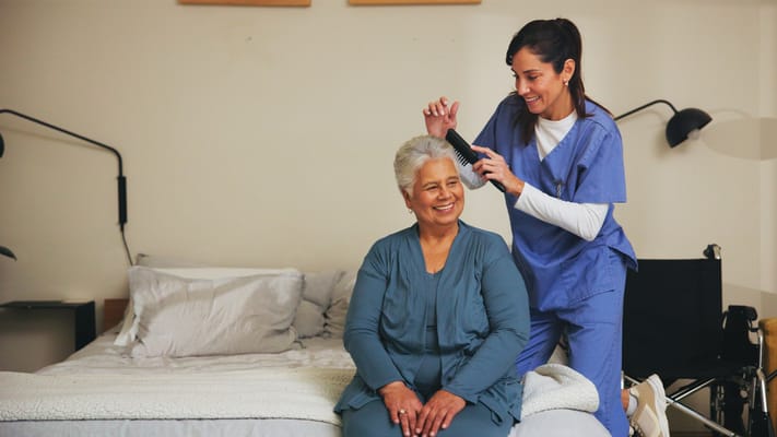 Care staff styling hair for a resident in a cozy room