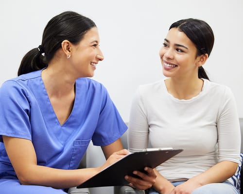 Staff member chatting with a resident in a bright room